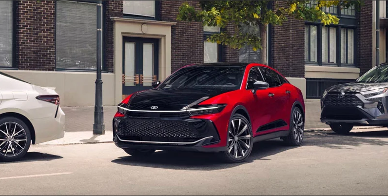 A photo of a red and black Toyota Crown parallel parking.